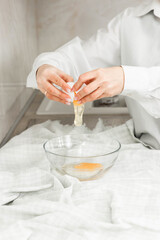 Obraz na płótnie Canvas breaking an egg into a bowl, cooking