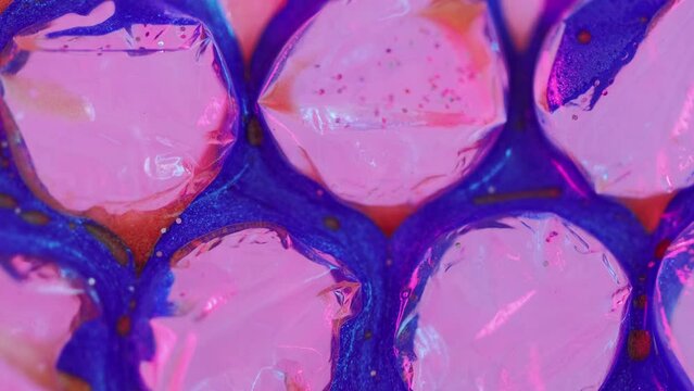 Paint bubbles. Glitter liquid drip. Defocused fluorescent pink blue red color shiny oil ink gloss water spill motion mosaic cell structure abstract art background.