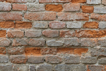Strongly decayed wet brick wall with damaged bricks