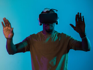 Immersed in a digital realm, an African American man navigates the virtual landscape with a VR...