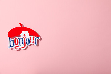 The word "bonjour" with a beret on a pink background. © Atlas
