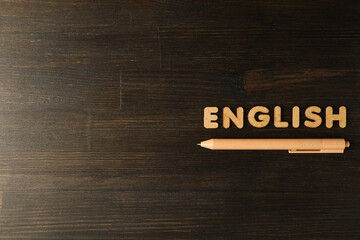 The word "English" and a notebook, the concept of learning English, on a dark background.