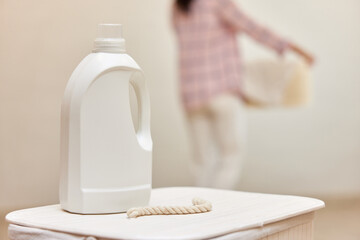 washing gel or laundry detergent on white laundry basket. Mock up, copy space.