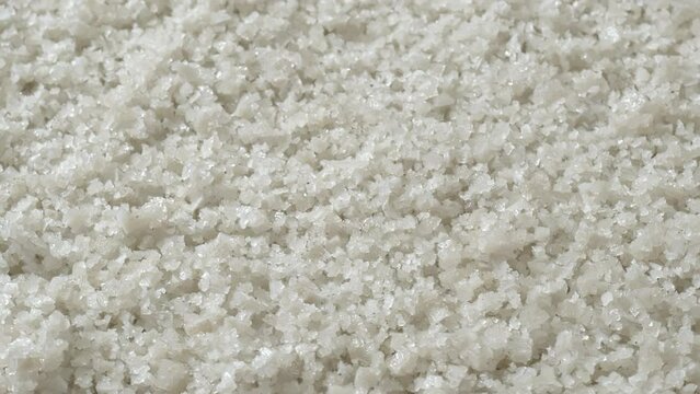 Gray sea salt from Guerande as an abstract food pattern. An intense mineral-rich sea salt that is unrefined and naturally grey. Table spin, selective focus.