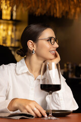 beautiful business woman having lunch in restaurant together with colleagues. man talking to female. girl is eating soup with spoon.smiling lady wearing eyeglasses.team drinking wine.