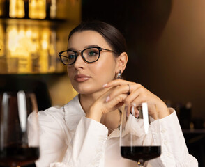 beautiful business woman having lunch in restaurant together with colleagues. man talking to female. girl is eating soup with spoon.smiling lady wearing eyeglasses.team drinking wine.