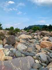 Fototapeta na wymiar rocks on the bank of the stream with blue sk