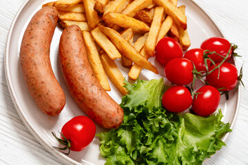 sausages with potato, lettuce, tomatoes, top view