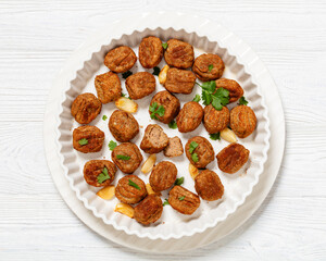 baked meatballs in white baking dish, top view