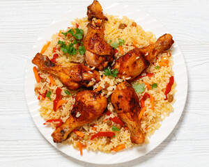 fried chicken drumsticks over rice pilaf, top view