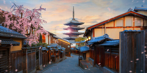 Scenic cityscape of Yasaka pagoda majestic sunset during full bloom cherry blossom and scatter...