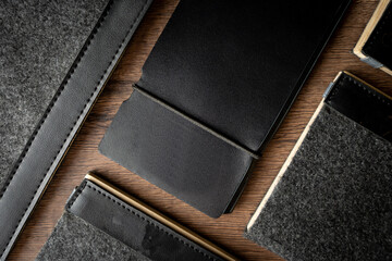 Handmade black wallet made of genuine leather on a wooden background. Close-up, top view.
