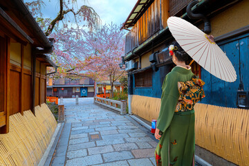 Naklejka premium Young Japanese woman in traditional Kimono dress at Tatsumi bashi bridge over Shirakawa river in Gion district, Kyoto