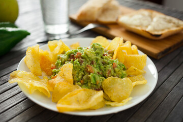 Traditional soft avocado salad. Guacamole with chips on a plate