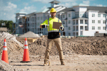 Hispanic man construction worker in helmet at building. Construction building. Construction site manager. Worker in helmet on the new building. Builder with hardhat helmet on construction site.