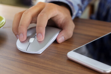 Fototapeta premium Close up of male hand using wireless keyboard and mouse in office desk. Casual working concept