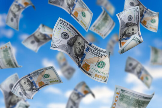 Flying dollars banknotes on the background sky. Money is flying in the air. 100 US banknotes new sample.