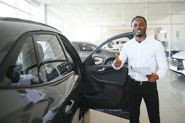Cars Dealership Concept. Auto Seller Afro Man Standing In Automobile Center