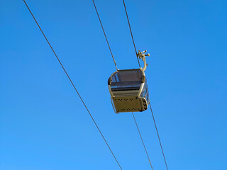 Jornada celestial: A experiência elevada da cabine de teleférico sobre o céu azul, transportando aventureiros para panoramas deslumbrantes