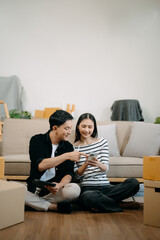 Happy asian young attractive couple man and woman with big boxes moving into a new house, new...