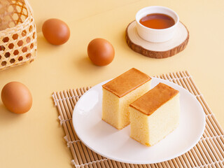 Japanese cotton egg cake in white plate on beige background. Minimalist product concept