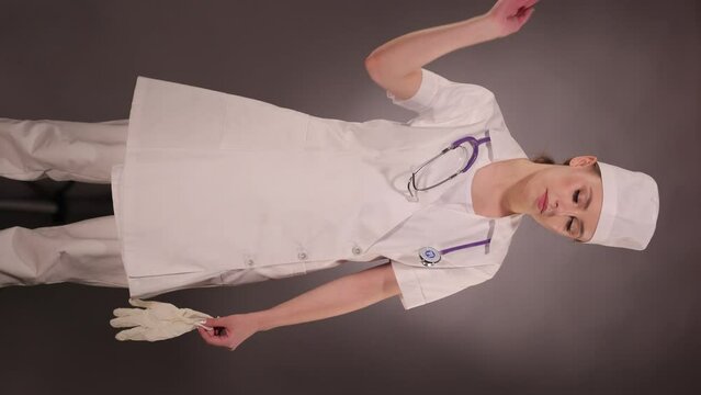 Emotional young woman doctor nurse in a white coat and hat