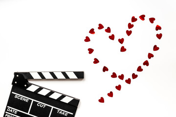 Love story movie concept. Clapperboard with red hearts, top view