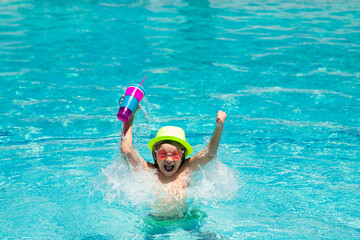 Boy kid in pool drinking cocktail. Happy lifestyle kids. Water toy, healthy outdoor activity for children. Kids beach fun.