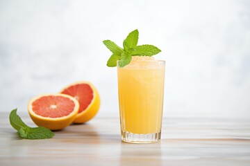 grapefruit juice in glass with mint garnish