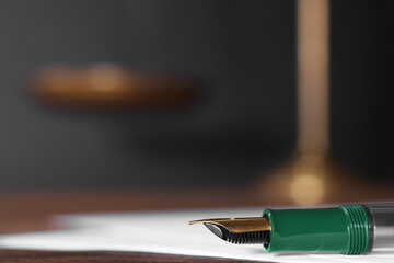 Fototapeta premium Fountain pen and paper document on table, closeup with space for text. Notary service