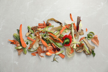 Peels of fresh vegetables on light grey marble table, flat lay
