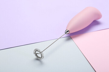 Pink milk frother wand on color background