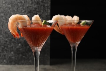 Tasty shrimp cocktail with sauce in glasses on table, closeup