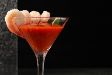 Tasty shrimp cocktail with sauce in glass on dark background, closeup. Space for text