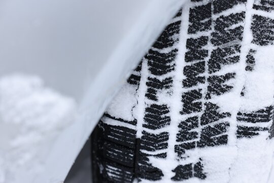 Fototapeta Car with winter tires covered with snow, closeup