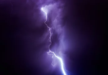Fotobehang Detalle de un rayo cayendo en una tormenta entre las nubes © carloskoblischek