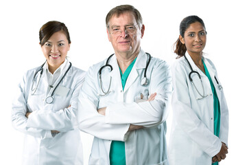 A diverse Medical team lead by a mature male Caucasian doctor.  They stand confidently in front of a white background.