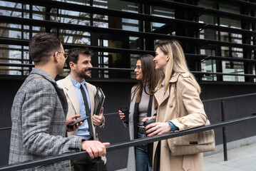 Group of young business people, job candidates standing in front of the office building waiting to be called to meeting with the employer. Businessmen and businesswomen waiting for human resources