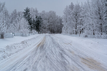 Fototapeta na wymiar Winter road through forest with frozen trees