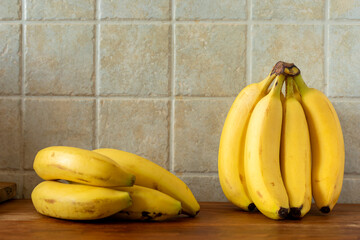 Two bunch of bananas on a kitchen table. Copy space for text.