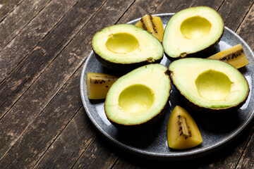 Avocado halves and yellow kiwi pieces on a plate. The sweet kiwi and the creamy avocado pair well...