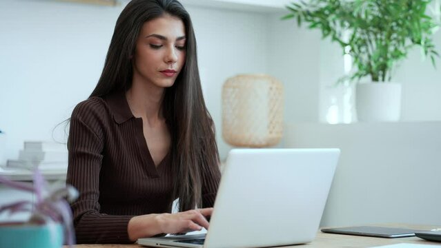 Video of elegant young business woman working with her laptop in a modern office.