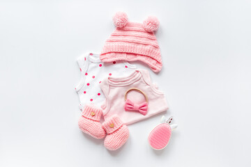 Set of baby girl dress - bodysuit with knitted hat and boots, top view. Kids clothing flat lay