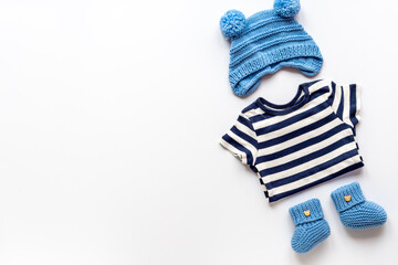 Set of baby boy dress - blue bodysuit with knitted hat and boots, top view. Kids clothing flat lay