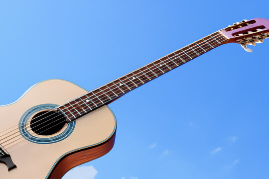 musical composition. there is a large wooden guitar on the blue sky, creative concept
