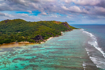 Aerial view of Anse Source D'Argent beach, La Digue Island, Seychelles, with palm trees and amazing granite rock formations.