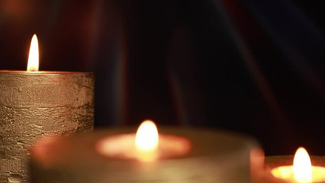 Golden candles on a black background with sun rays