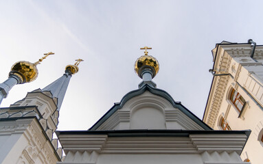 bottom view golden domes of christian church with crosses on blue sky background