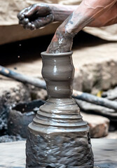 Hands of a potter, creating an earthen jar