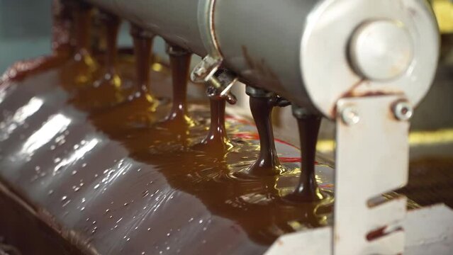 Conveyor with liquid chocolate. Confectionery factory. Chocolate factory. Candy production.